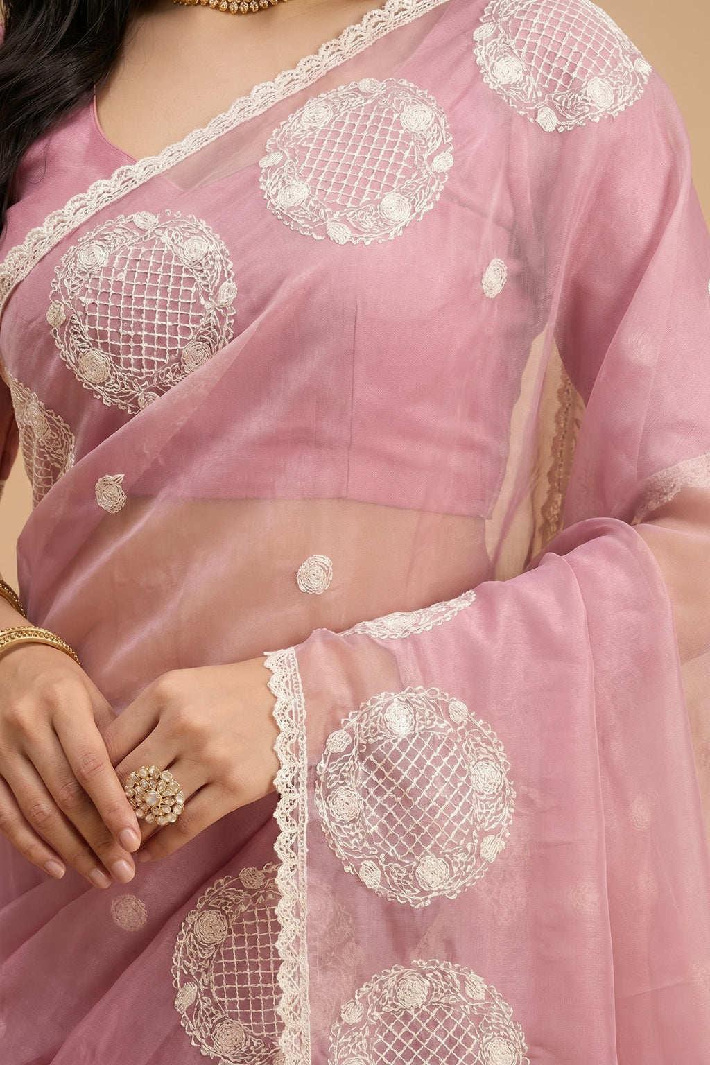 Pink saree with white embroidery on a beige background