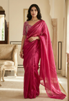 Woman wearing a pink saree in an elegant room
